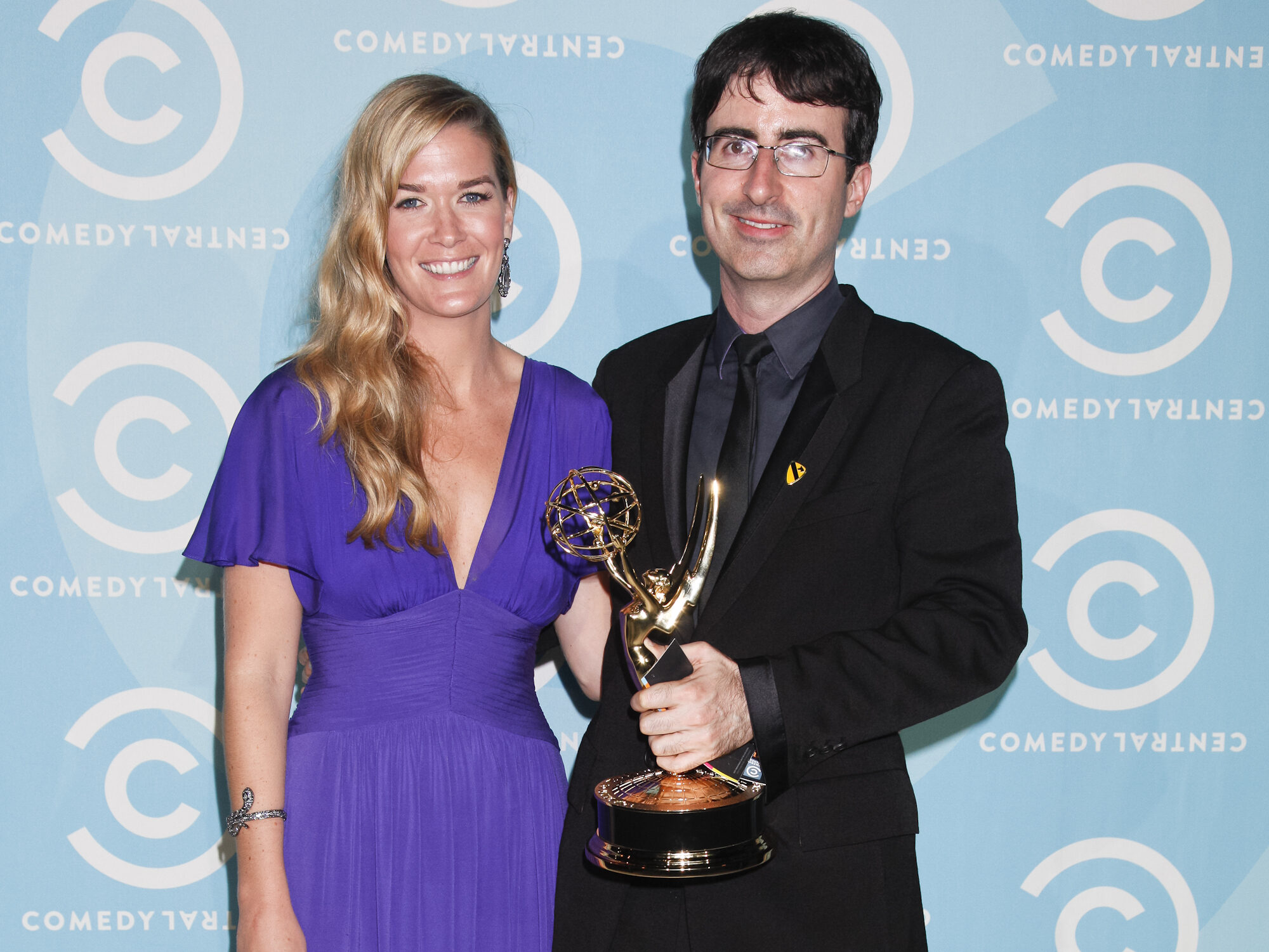 Kate Norley (L) in purple dress standing next to John Oliver